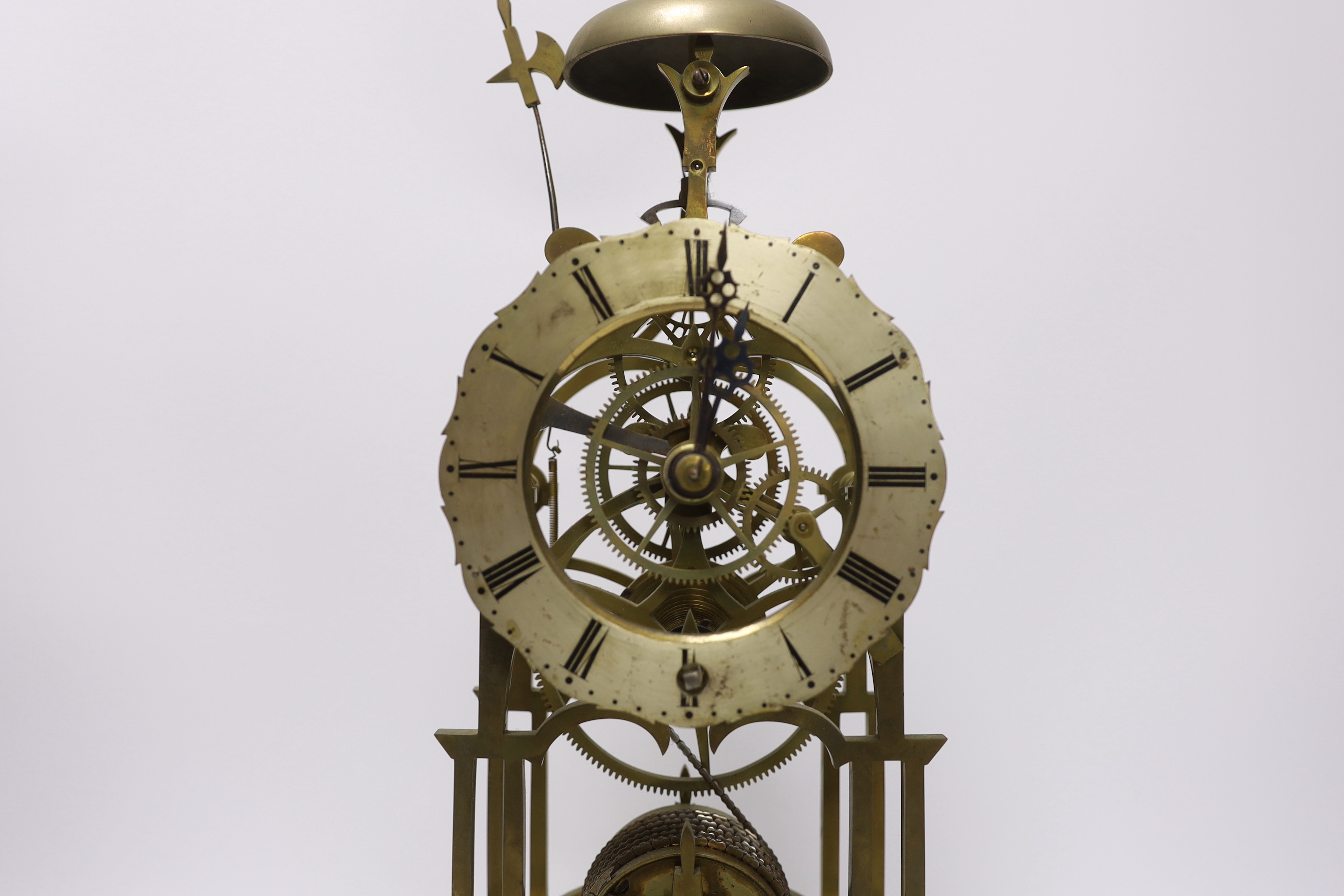 A skeleton clock with Roman numeral dial, raised on white marble base, pendulum and key, 45cm